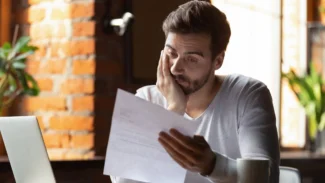 Hombre leyendo una carta de baja con cara de decepción